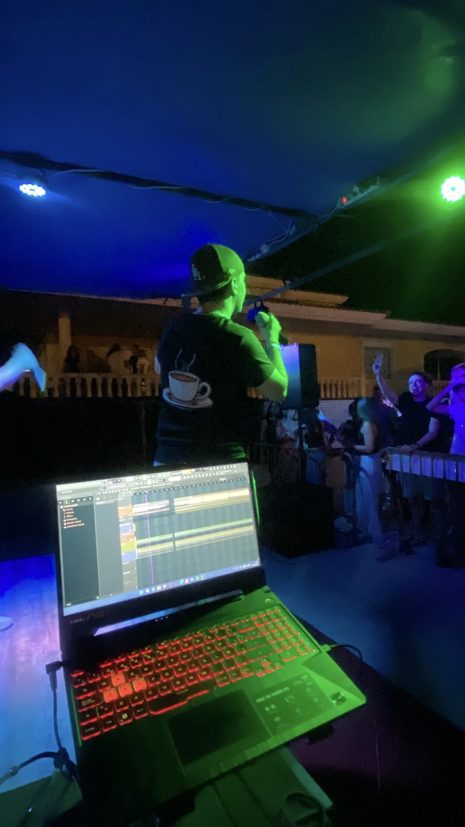 Directo con luces verdes y el portátil en el escenario