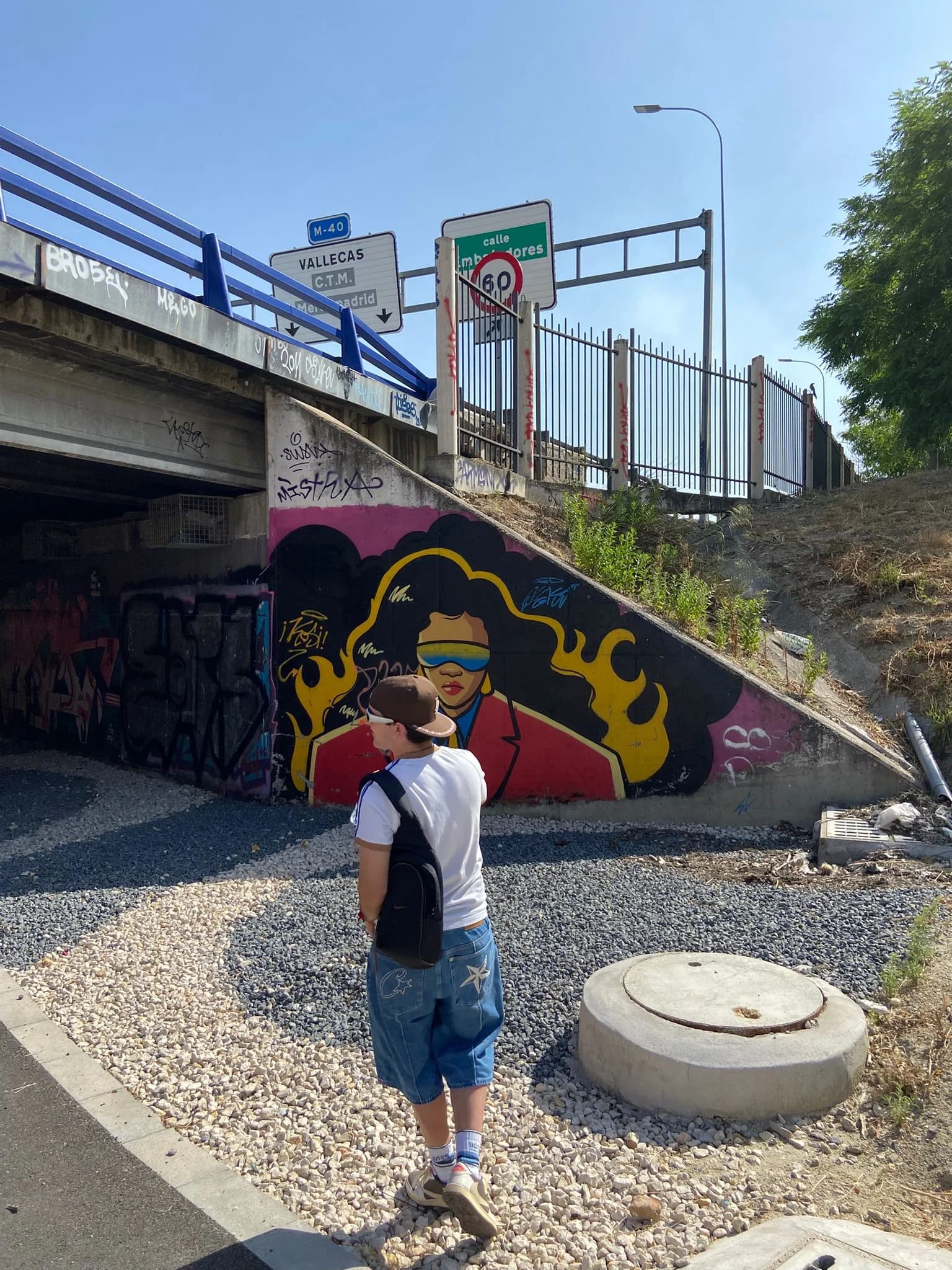 MÖKA frente a un mural de grafiti