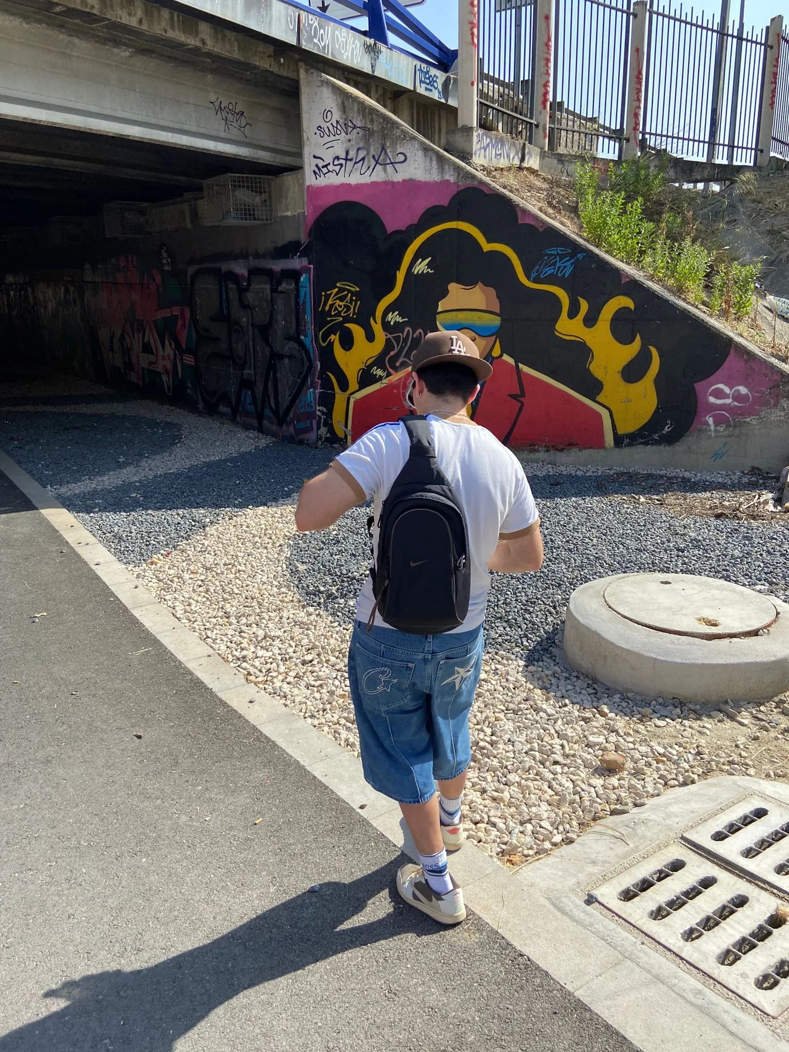 MÖKA frente a un mural de grafiti